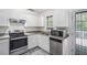 Bright kitchen with white cabinets, stainless steel appliances and grey countertops at 7835 Teton Trl, Douglasville, GA 30134
