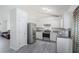 Clean white kitchen with stainless steel appliances, and light gray flooring at 7835 Teton Trl, Douglasville, GA 30134