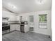 Bright kitchen with stainless steel appliances, white cabinets, and gray plank floors at 7835 Teton Trl, Douglasville, GA 30134