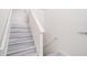 Neutral stairway with gray plank flooring and white trim at 7835 Teton Trl, Douglasville, GA 30134