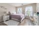 Cozy bedroom features two large windows, a writing desk, and a comfortable bed with lots of pillows at 122 Susobell Pl, Woodstock, GA 30188
