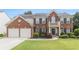 Beautiful two-story brick home with manicured lawn, shutters and white trim accents at 122 Susobell Pl, Woodstock, GA 30188
