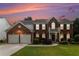 Beautiful brick home featuring an attached two-car garage, manicured lawn, and second story balcony at 122 Susobell Pl, Woodstock, GA 30188