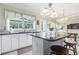 Kitchen island featuring granite countertops, white cabinetry, and seating with an open view into the dining area at 122 Susobell Pl, Woodstock, GA 30188
