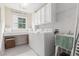 Functional laundry room featuring washer, dryer, sink, and ample storage cabinets at 122 Susobell Pl, Woodstock, GA 30188