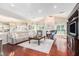 Spacious living room with hardwood floors, fireplace, vaulted ceilings, and seamless kitchen access at 122 Susobell Pl, Woodstock, GA 30188