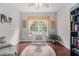 Bright home office with natural light, built-in shelving, wood floors, and a comfortable work space at 122 Susobell Pl, Woodstock, GA 30188