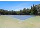 Community tennis courts with lush green grass, surrounded by shade trees and beautiful landscape at 122 Susobell Pl, Woodstock, GA 30188