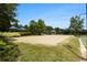 Community sand volleyball court with professional net, blue shade umbrellas, and lush green landscape at 122 Susobell Pl, Woodstock, GA 30188