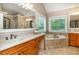 Bright bathroom with double vanities, soaking tub, granite countertops, and two large mirrors at 2850 Seagrave Way, Marietta, GA 30066