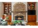 A stone fireplace is flanked by built-in shelves in this naturally lit living room with hardwood flooring at 2850 Seagrave Way, Marietta, GA 30066