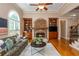 Well-lit living room featuring a stone fireplace, built-in bookshelves, large windows, and hardwood floors at 2850 Seagrave Way, Marietta, GA 30066