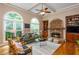 Bright living room featuring arched windows, a stone fireplace, built-in shelving, and hardwood floors at 2850 Seagrave Way, Marietta, GA 30066