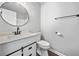 Bathroom featuring white vanity, round mirror, and contrasting black hardware at 3232 Valley View St, Powder Springs, GA 30127