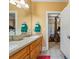 Bathroom featuring double sinks with granite countertops, wood cabinets, and a connecting door to the main bedroom at 390 Glengarry Chase, Covington, GA 30014