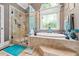 A stylish primary bathroom features a glass enclosed shower, and luxurious soaking tub at 390 Glengarry Chase, Covington, GA 30014