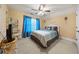 Bright bedroom featuring a ceiling fan, tan walls, and blue curtains for a calming atmosphere at 390 Glengarry Chase, Covington, GA 30014