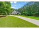 Brick home with long driveway, an expansive lawn and lush landscaping at 390 Glengarry Chase, Covington, GA 30014