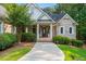 Charming brick home featuring a welcoming entrance, lush landscaping, and sidewalk at 390 Glengarry Chase, Covington, GA 30014