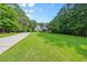 Brick home with long driveway, an expansive lawn and lush landscaping at 390 Glengarry Chase, Covington, GA 30014