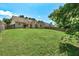 Expansive backyard with a large grassy area surrounded by a wooden fence and mature trees at 1553 Queen Elizabeth Dr, Locust Grove, GA 30248