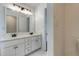 Well-lit bathroom featuring a double vanity and a large mirror at 1553 Queen Elizabeth Dr, Locust Grove, GA 30248