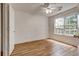 Bright bedroom with hardwood floors, ceiling fan, and a large window providing natural light at 1553 Queen Elizabeth Dr, Locust Grove, GA 30248