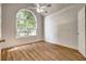 Bright bedroom with hardwood floors, a ceiling fan, and a large window at 1553 Queen Elizabeth Dr, Locust Grove, GA 30248