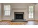 A brick fireplace with black metal doors provides a cozy focal point next to a large window at 1553 Queen Elizabeth Dr, Locust Grove, GA 30248
