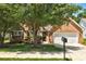 Charming brick home with a well-manicured front yard and mature trees at 1553 Queen Elizabeth Dr, Locust Grove, GA 30248