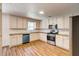 Bright kitchen features wooden floors, white cabinetry, and stainless steel appliances at 1553 Queen Elizabeth Dr, Locust Grove, GA 30248