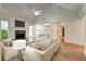 A bright living room features a fireplace, white sofas, and views to the kitchen and dining area at 1553 Queen Elizabeth Dr, Locust Grove, GA 30248