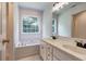 Bright main bathroom with double sinks, tub, and a large window at 1553 Queen Elizabeth Dr, Locust Grove, GA 30248
