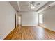 Sunlit primary bedroom with tray ceiling, wood floors, and walk-in closet access at 1553 Queen Elizabeth Dr, Locust Grove, GA 30248