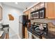 Functional kitchen featuring black countertops, a stainless steel refrigerator, and wooden cabinets for storage at 3115 Seven Pines Ct # 308, Atlanta, GA 30339