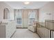Cozy Bedroom with white furnishings, including a crib, dresser, and comfy armchair at 346 Ardmore Ct, Atlanta, GA 30309