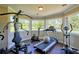 Bright exercise room featuring multiple workout machines and large windows with views of the yard at 794 Rutland Ct, Lithonia, GA 30058