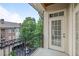 Private balcony with iron railing overlooking mature trees, building and parking area at 825 Highland Lane Northeast Ne # 1313, Atlanta, GA 30306