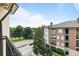 Balcony view of tree-lined street and neighboring brick building, offering a serene urban outlook at 825 Highland Lane Northeast Ne # 1313, Atlanta, GA 30306