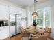 Charming dining area with stainless steel appliances, white cabinets, and a round wood table with seating for four at 825 Highland Lane Northeast Ne # 1313, Atlanta, GA 30306