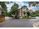 Exterior of a brick building with lush landscaping, a circular driveway, and plenty of parking spaces at 825 Highland Lane Northeast Ne # 1313, Atlanta, GA 30306