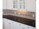 Close-up showcasing the kitchen's granite countertops, tile backsplash, and white cabinetry at 825 Highland Lane Northeast Ne # 1313, Atlanta, GA 30306