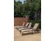 Community pool area with lounge chairs, brick wall, and mature landscaping at 825 Highland Lane Northeast Ne # 1313, Atlanta, GA 30306