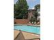 Community pool offering lounge chairs, brick privacy wall and mature trees and landscaping at 825 Highland Lane Northeast Ne # 1313, Atlanta, GA 30306