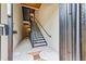 Hallway staircase with black metal railings and neutral-colored tile flooring with inset brown tile design feature at 825 Highland Lane Northeast Ne # 1313, Atlanta, GA 30306