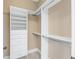 Walk-in closet with white shelving and drawers and neutral carpeting at 825 Highland Lane Northeast Ne # 1313, Atlanta, GA 30306