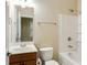 Bright bathroom featuring a toilet, a tub with shower, a sink with vanity, and a mirror at 5060 Windcrest Lane, Alpharetta, GA 30022