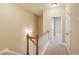 Hallway featuring neutral walls, carpet, a wooden railing, and doors leading to various rooms at 5060 Windcrest Lane, Alpharetta, GA 30022