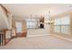 Open-concept living space with kitchen and staircase access, plush carpets and natural light at 5060 Windcrest Lane, Alpharetta, GA 30022
