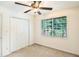 Clean bedroom with a ceiling fan, double door closet, and a window overlooking a lush, green backyard at 6940 Roswell Road Rd # 16B, Atlanta, GA 30328